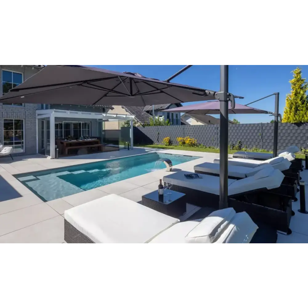 Svart rottingloungestolar med vita kuddar vid Leisurepools Precision pool